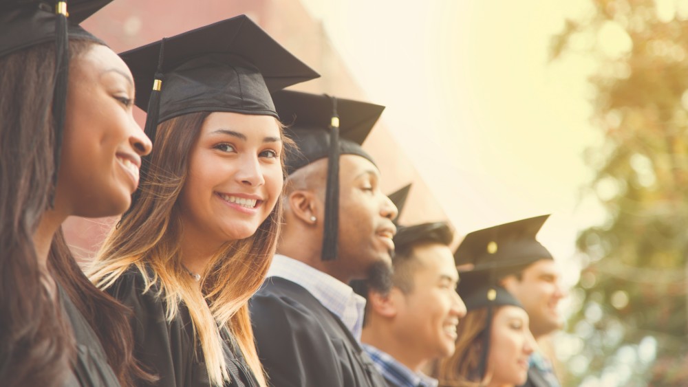 Graduation_StudentsGroup_Smiling_Outdoor_GettyImages-907837926